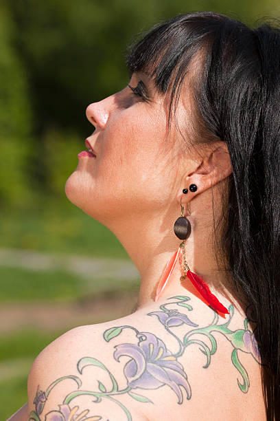Tattoo Woman with tattoo on her left shoulder. back shoulder tattoos for women pictures stock pictures, royalty-free photos & images