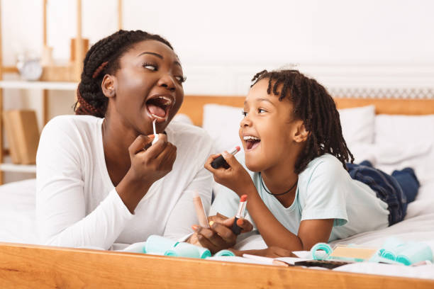 istock Little afro girl doing makeup with her mom 1212741499
