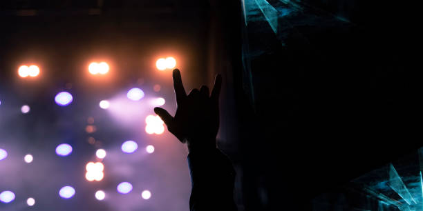 istock rock festival performance graphic design poster with abstract effect on black space for copy or your text here fan person hand on music stage background view with illumination glare and lights 1212741575
