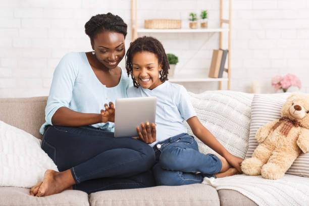 istock Happy afro family spending time together using tablet 1212741619