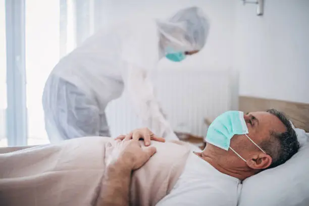 Photo of Senior man lying in hospital bed because of coronavirus infection