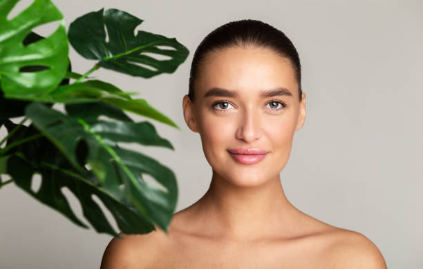 istock Calm girl with green palm leaf near face 1212742017