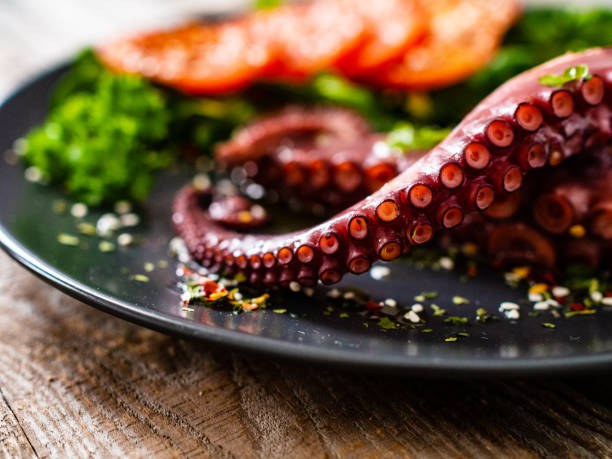 istock Fried octopus and vegetables on wooden table 1212742218