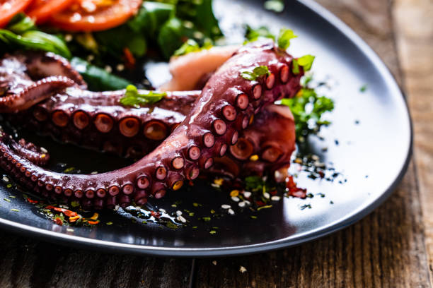 istock Fried octopus and vegetables on wooden table 1212742294
