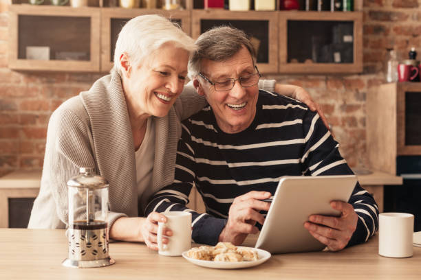 istock Cheerful Senior Couple Spending Time With Digital Tablet In Kitchen 1212742958