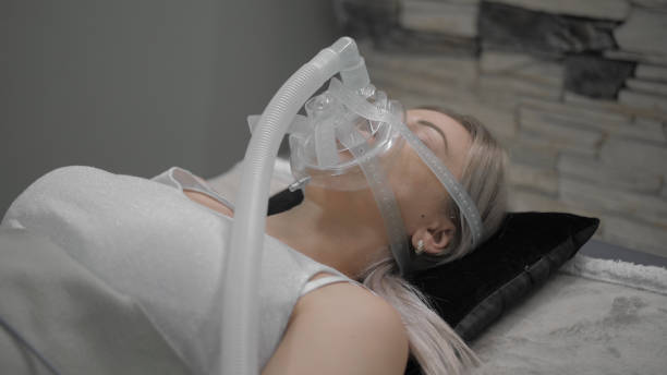 istock Girl lies on bed with artificial respiration mask 1212743069
