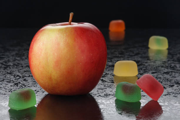 검은 배경에 빨간 사과와 마멀레이드 - gelatin dessert orange fruit marmalade 뉴스 사진 이미지
