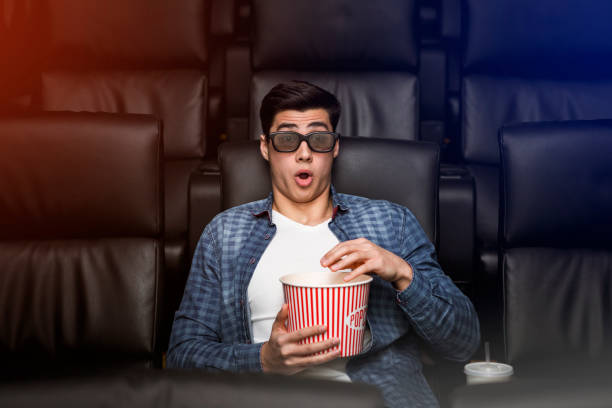 young guy with shocked look on his face in film theater - audience surprise movie theater shock imagens e fotografias de stock