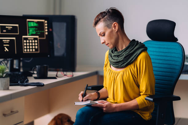 Businesswoman sitting at the desk and writing notes