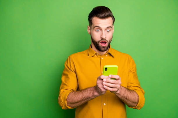 istock Portrait of his he nice attractive amazed stunned bearded guy in formal shirt using 5g app reading fake news isolated on bright vivid shine vibrant green color background 1212746721