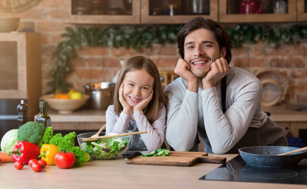 istock Dad And Little Daughter Posing At Kitchen While Cooking Healthy Food 1212746907