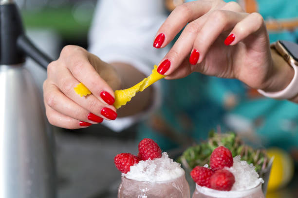 Hands of a professional bartender decorate a cocktail.