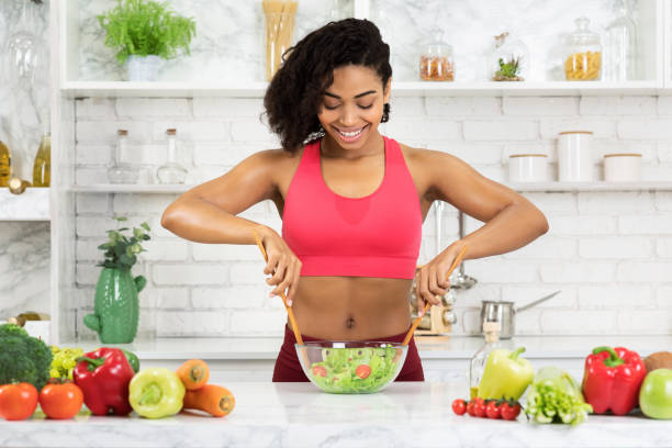 istock Beautiful young african girl preparing vegetable salad 1212748005