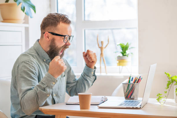 Success and goal achievement concept. Success and goal achievement concept. Happy businessman feel excitement scream raising fists looking at the laptop achieving life goal, celebrating business success great result make winner gesture sales win stock pictures, royalty-free photos & images