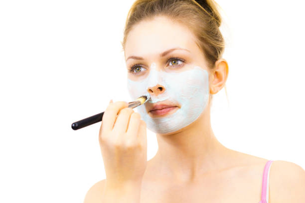 istock Girl apply green mud mask to face 1212750280
