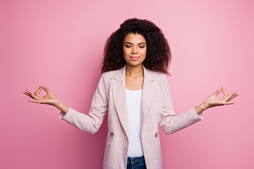 Photo of beautiful dark skin business lady hold fingers om position, think mantra eyes closed meditating break work pause wear plaid blazer jeans isolated pink pastel color background