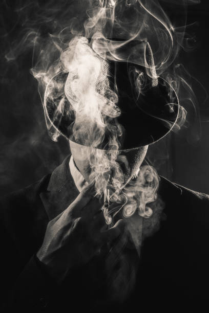 istock Retro man in smoke wears suit, tie and hat 1212755686