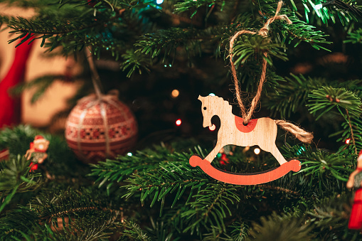 Horse decoration hanging in a Christmas tree. Equestrian postcard or background for Christmas greetings. Suitable for horse riding theme greetings, postcards, backgrounds and social media posts just in time for Christmas.