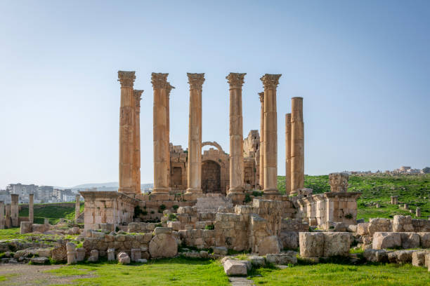 blick auf den tempel von artemis an der historischen römischen stätte von gerasa, jerash, jordanien. blauer himmel, sonniges wetter und grünes gras im frühling - artemis tempel gerasa stock-fotos und bilder