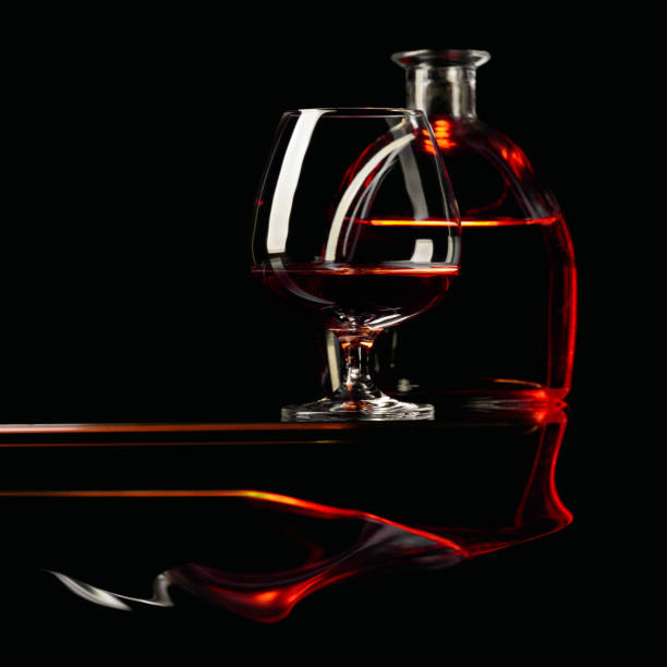 istock Snifter and bottle of brandy on a black background. 1212758978