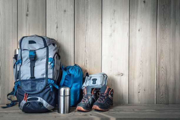 camping equipment, shoes, a backpack and a thermos on a wood background - 4603 imagens e fotografias de stock