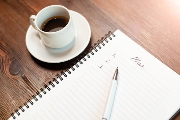 Plan with to do list and coffee on wooden table