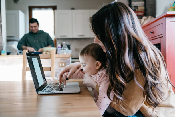 istock A little girl using a laptop with her mom while the dad is cooking in the kitchen 1212761079