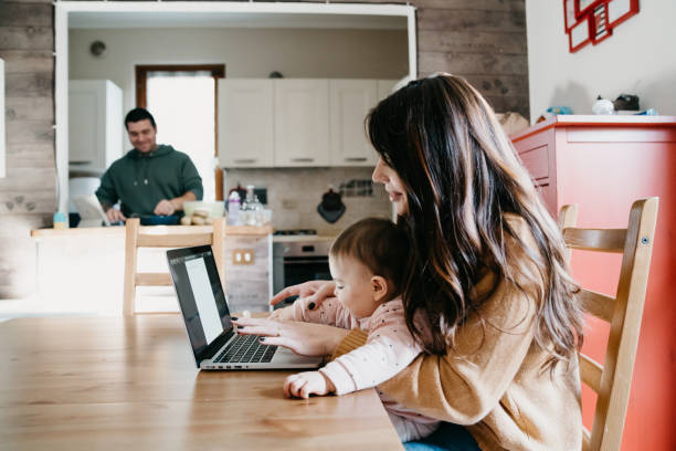 istock A little girl using a laptop with her mom while the dad is cooking in the kitchen 1212761081