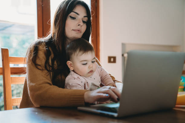 istock A young mother is working at home using computer while she's taking care of her daughter 1212761092