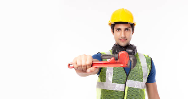 istock Portrait young handyman standing, holding adjustable wrench and showing tool, isolated white background, copy space. Successful worker or repairman wearing safety helmet safety vest, ready fix service 1212761534