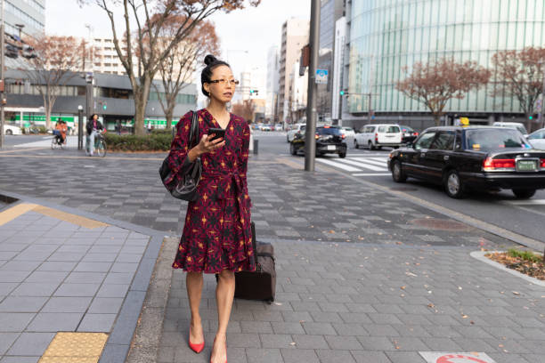 istock Japanese business worman walking with suitcase 1212762475