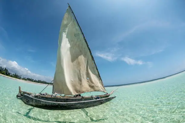 beautiful holiday seascape with crystal clear turquoise color water, Indian ocean, blue sky and traditional wooden sail boat
