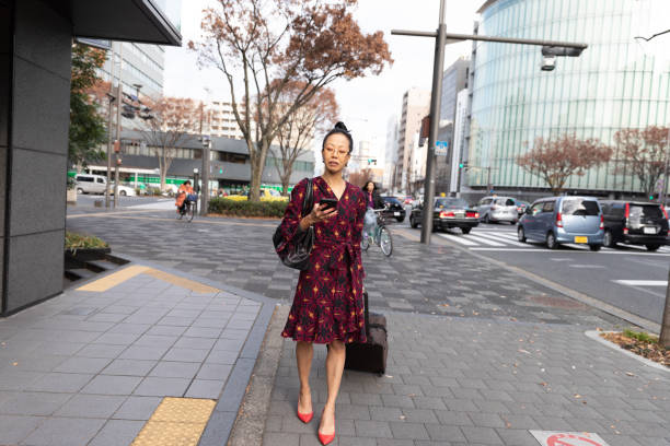 istock Japanese business worman walking with suitcase 1212762884