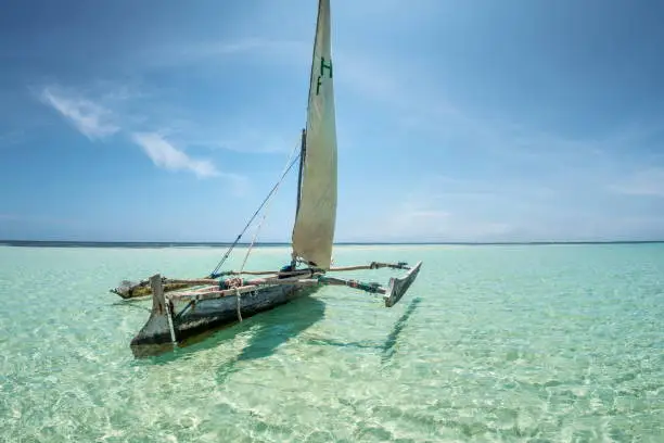 beautiful holiday seascape with crystal clear turquoise color water, Indian ocean, blue sky and traditional wooden sail boat