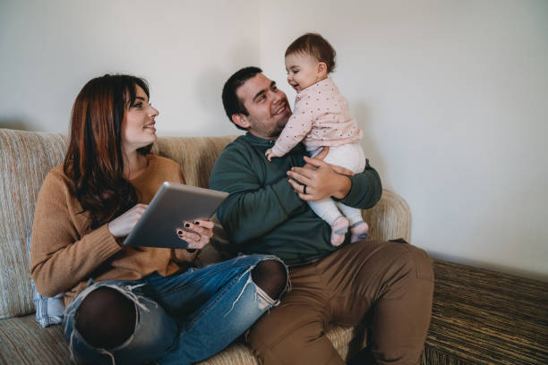 istock Family on the sofa at home - Mom is using a digital tablet 1212764618