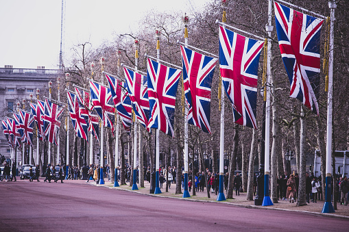 1st February, 2020 - Tourist walking down The Mall, Westminster, London,  decorated with union jack flags