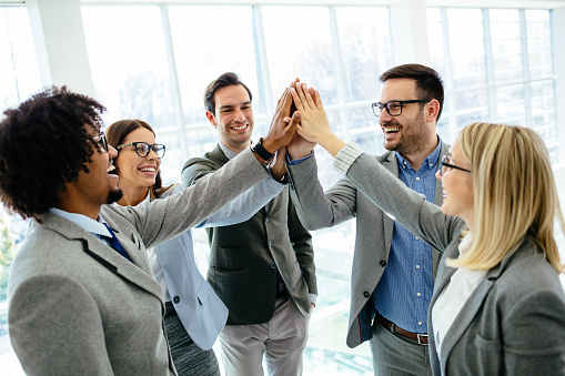 Excited business team give high five celebrating corporate success