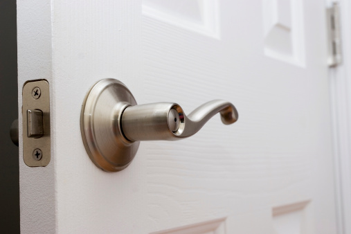 Silver metal deadbolt lock on a white door