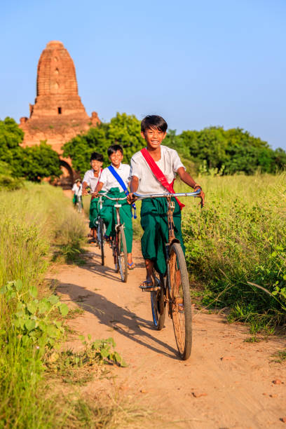 istock Burmese school children riding a bicycle in Bagan, Myanmar 1212767741