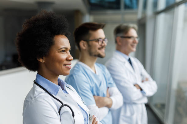 tir de trois médecins restant ensemble - healthcare and medicine smiling group of people lab coat photos et images de collection