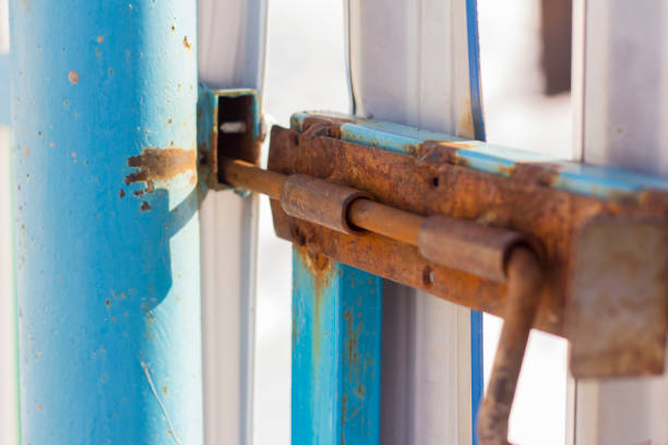 istock Rusty old slide bolt or tower bolt on a worn green door. 1212768250