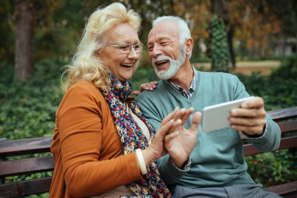 istock Senior couple using smart phone in the park 1212769648