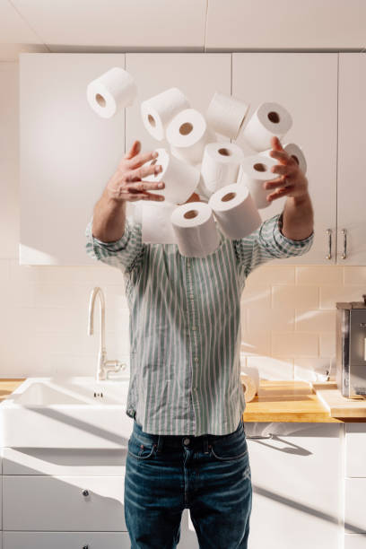 istock Man hoarding toilet paper holding many rolls 1212770415