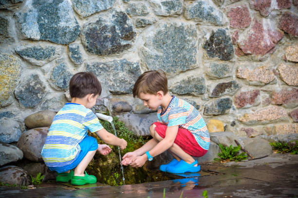 istock the boy drinks cold water outdoors from the pipe 1212771270