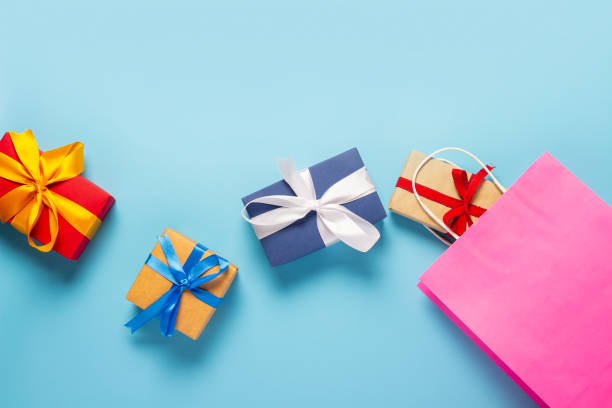 istock from a pink bag packing boxes fall out on a blue background. Gift bag and boxes. Concept of holidays, shopping, sale, discounts. Banner. Top view, flat lay 1212773709