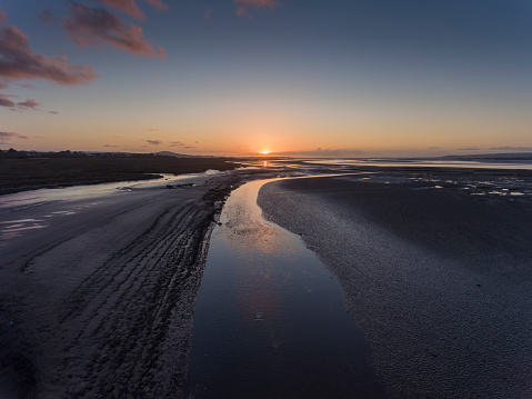 A river in the mud at low tide on the Loughor Estuary, Penclawdd, North Gower, Swansea, UK