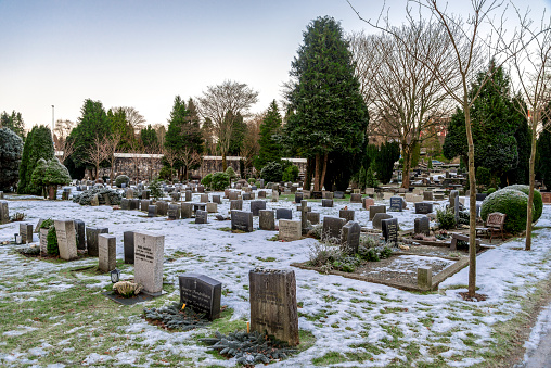 Multiple tombstones and snow covered ground in scenic Lagard cemetery during winter season, Stavanger, Norway, December 2017