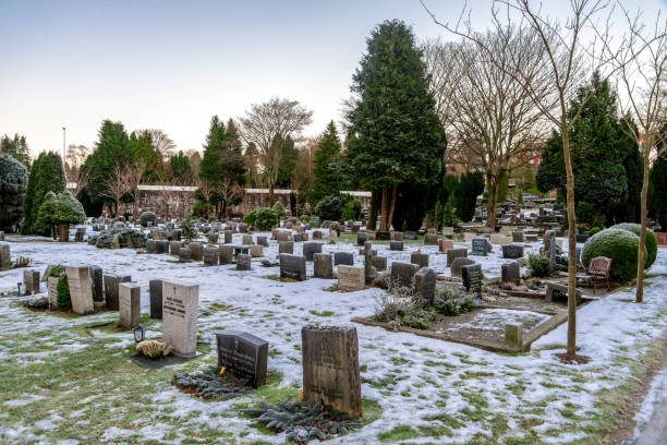 Multiple tombstones and snow covered ground in scenic Lagard cemetery during winter season, Stavanger stock photo