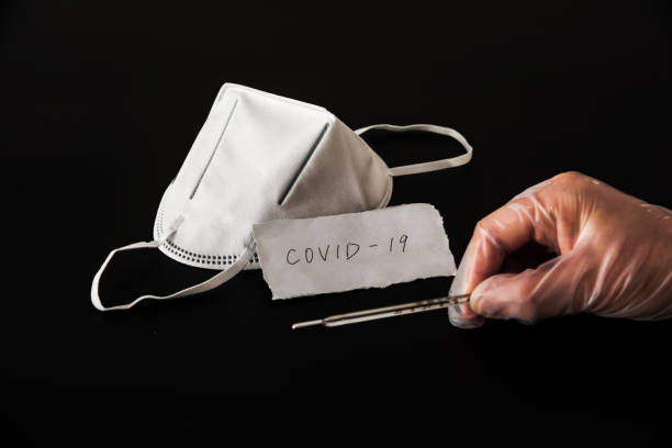 istock Disposable medical mask in black background 1212774878