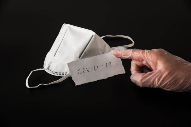 istock Disposable medical mask in black background 1212774997